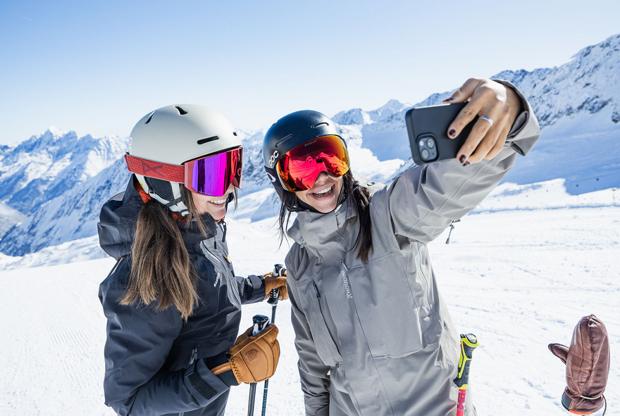 Zwei Skifahrerinnen machen ein Selfie auf der Skipiste 